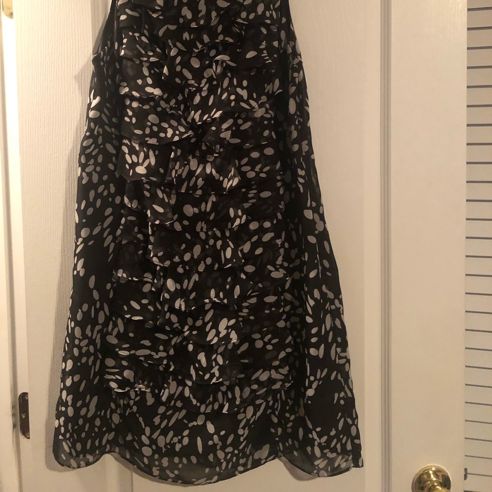 Navy blue sleeveless dress with white polka dots. The dress has ruffles in front